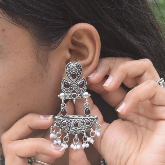 Woman adjusting a large, oxidised jewellery.